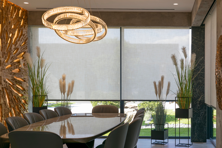 dining room with floor-to-ceiling motorized solar shades, sculptural chandelier, and floor-to-ceiling window views.