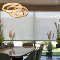 dining room with floor-to-ceiling motorized solar shades, sculptural chandelier, and floor-to-ceiling window views.