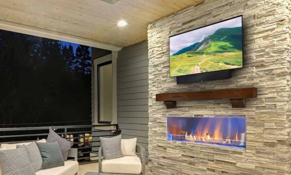 <span class="uk-h4">outdoor TV mounted above a fireplace on a patio.</span>